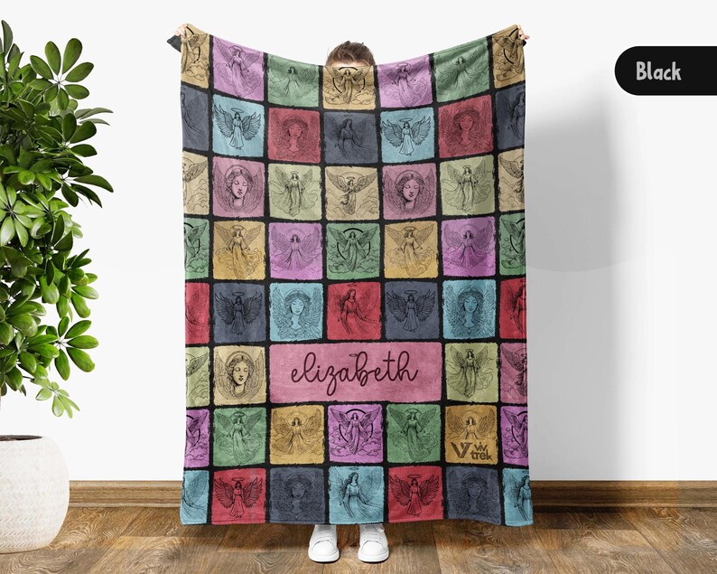 May include: A rectangular throw blanket featuring a grid of colorful squares, each containing a black line-art illustration of an angel. A central horizontal rectangle displays the name elizabeth in cursive script. The background colors include pink, blue, green, yellow, and purple.