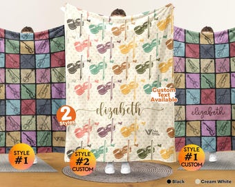 May include: A soft throw blanket featuring a repeating pattern of violins and bows in various colours. The centre displays the name elizabeth in cursive script. The design includes small butterfly accents and a cream white background colour.