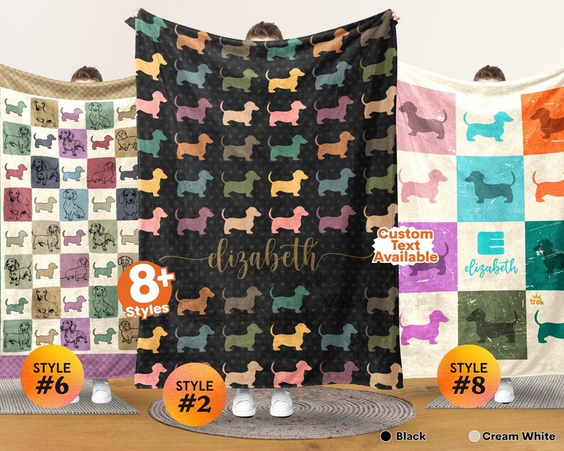 May include: Three rectangular fleece blankets featuring dachshund dog patterns. The left blanket has a grid of colorful dogs. The center black blanket displays a repeating dog pattern with the name elizabeth in script. The right blanket has a grid with the name elizabeth.