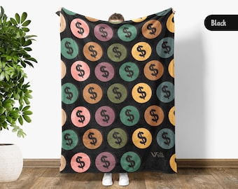 May include: Black blanket featuring a repeating pattern of colorful circles with dollar signs. The circles are in shades of pink, green, orange, purple, and yellow. The blanket is held up by a person.