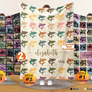 May include: Three soft blankets featuring shark patterns. The left blanket has a grid of sharks on dark backgrounds. The center blanket is cream white with colorful sharks and the name elizabeth. The right blanket has a grid with the name elizabeth.