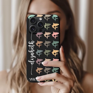 May include: Black phone case featuring a pattern of colorful shark silhouettes. The case has the name "Elizabeth" in a white script font. The phone case has a camera module with three lenses.
