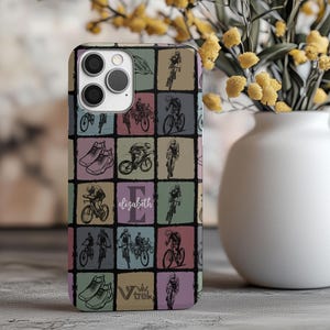 May include: A personalized phone case featuring a grid pattern with cycling-themed illustrations in various colors. The design includes images of cyclists, running shoes, and the name "Elizabeth". The case is designed for a smartphone.