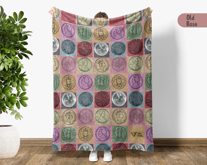 May include: A colorful blanket featuring a repeating pattern of vintage coin illustrations in square blocks. The coins are in various colors, including green, pink, and blue, set against a multi-colored background. The blanket has a soft, cozy appearance.