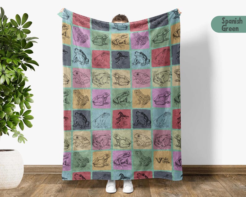 Puede incluir: Una manta suave y mullida con un patr&oacute;n repetitivo de ranas en varias poses sobre un fondo colorido. La manta est&aacute; hecha de un material suave y c&oacute;modo y es perfecta para acurrucarse en el sof&aacute;.