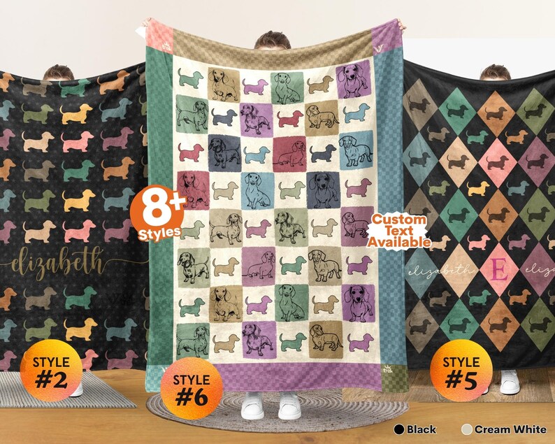 May include: Three rectangular fleece blankets featuring dachshund illustrations. The left blanket is black with a repeating dog pattern and the name elizabeth. The center blanket has a grid of colorful squares with dog sketches. The right blanket has a diamond pattern with the name elizabeth and the letter E.