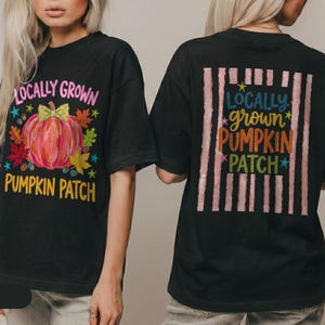 Könnte beinhalten: Ein schwarzes T-Shirt mit einem Frontaufdruck eines rosafarbenen Kürbisses mit grüner Schleife, Herbstblättern und dem Text "LOCALLY GROWN PUMPKIN PATCH". Die Rückseite zeigt ein vertikales Streifenmuster mit dem farbigen Text.