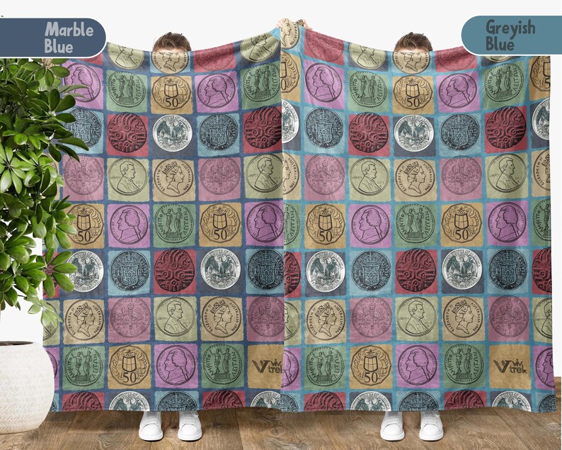 May include: A blanket with a repeating pattern of vintage coins in various colors, including blue, pink, and gold. The coins are set against a grid of squares, creating a patchwork effect. The blanket is held up by a person.