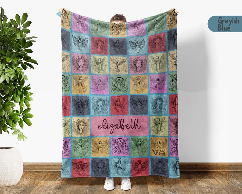 May include: A rectangular throw blanket featuring a grid of colorful squares, each displaying a unique black line-art illustration of an angel. The center square contains the name elizabeth in cursive script, and the logo viv trek is visible.