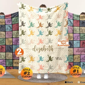 May include: A soft throw blanket featuring a repeating frog pattern in various colors. The center design displays the name elizabeth in cursive script. The blanket is available in two styles, one with a grid of frog illustrations and one with a cream background.