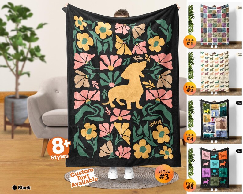 May include: A black rectangular throw blanket featuring a central golden yellow dachshund silhouette surrounded by a repeating pattern of stylized pink, yellow, and green flowers. The word vivtrek is printed in small yellow letters near the bottom right.