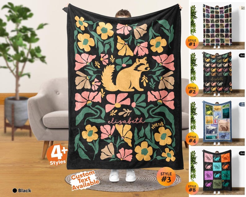 May include: A black rectangular throw blanket featuring a central illustration of a tan raccoon surrounded by stylized pink, yellow, and green flowers. The name elizabeth is printed in a cursive white font below the raccoon, with the text vivtrek nearby.
