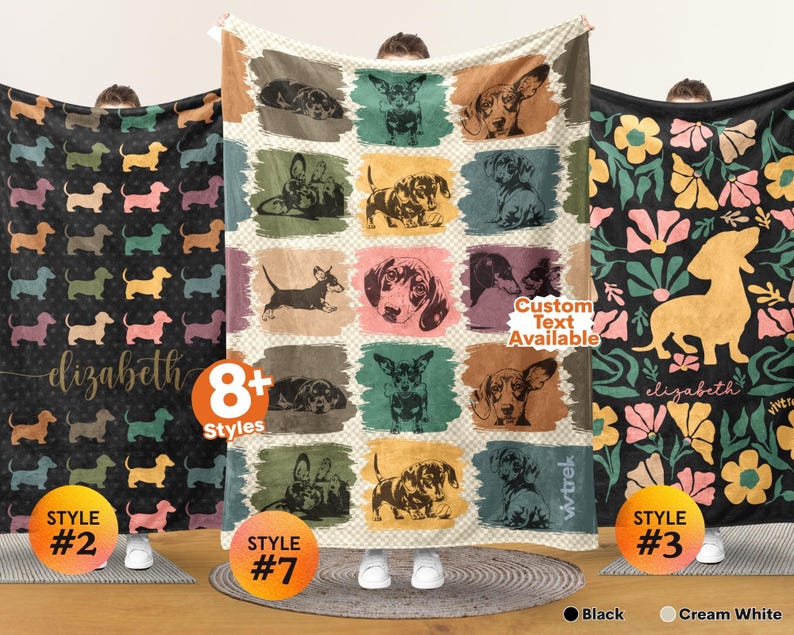 May include: Three rectangular blankets featuring dachshund designs. The left blanket is black with colorful dog silhouettes and the name Elizabeth. The center blanket has a grid of dachshund illustrations on a cream background. The right blanket is black with floral patterns and a large yellow dachshund silhouette with the name Elizabeth.