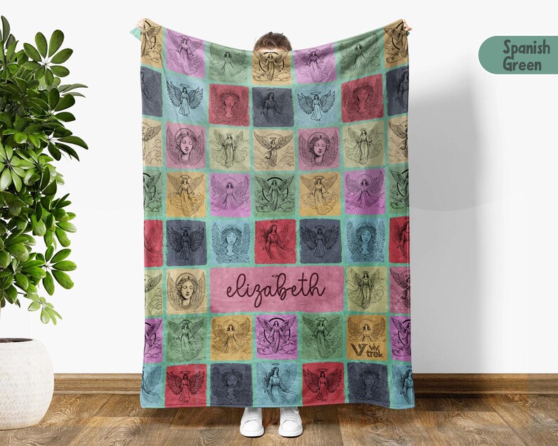 May include: A rectangular fleece blanket featuring a grid pattern of various angel illustrations in shades of pink, blue, yellow, and green. The center of the blanket displays the name elizabeth in a dark script font, with a small logo in the corner.