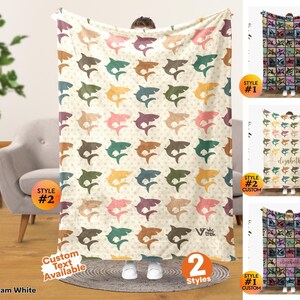 May include: A cream white throw blanket featuring a repeating pattern of sharks in various colors including teal, orange, pink, and brown. The blanket displays the Viv Trek logo in the bottom right corner and offers custom text options.