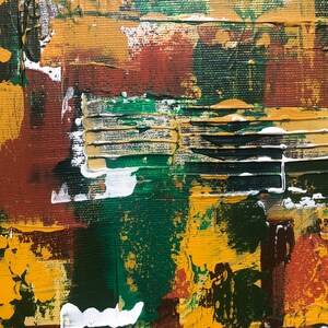 Op de afbeelding: Abstract schilderij met een getextureerd oppervlak. Het kunstwerk toont een palet van mosterdgeel, diepgroen en bruin, met witte accenten. De penseelstreken zijn zichtbaar, waardoor een gelaagd effect ontstaat. Het schilderij heeft een moderne, artistieke uitstraling.