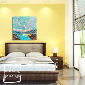 May include: A bedroom interior with a modern bed, a bedside table, and a large abstract painting on the wall. The painting features a blue and green landscape with a pink sky.