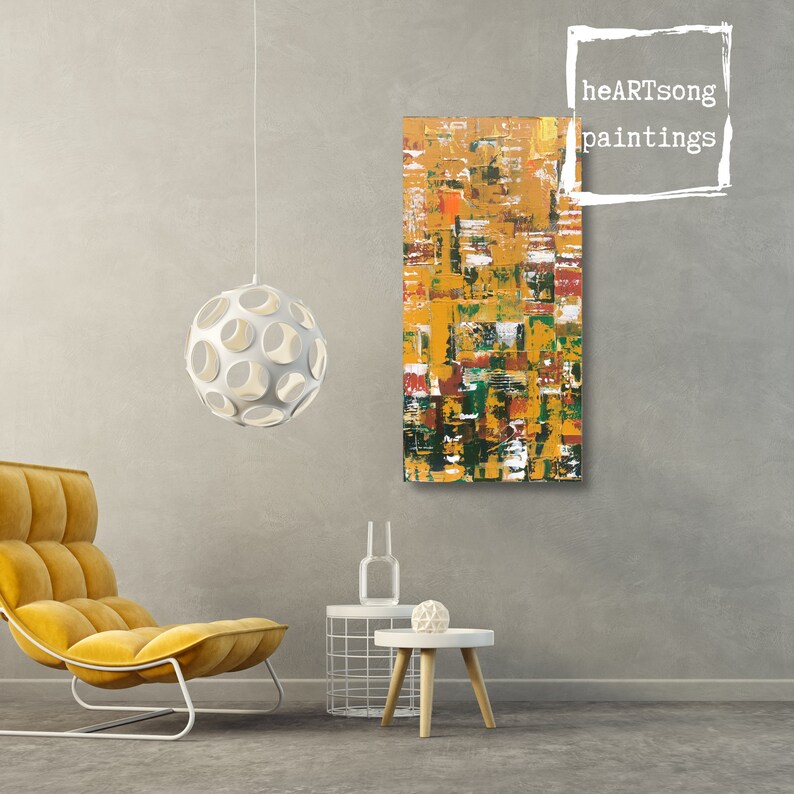 Op de afbeelding: Abstract schilderij met een textuur, met een mix van gele, oranje, rode, groene en witte penseelstreken. Het rechthoekige kunstwerk hangt aan een grijze muur. De tekst "heARTsong paintings" staat rechtsboven.