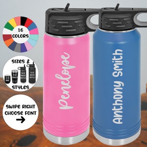 May include: Two personalized stainless steel water bottles with lids. The bottle on the left is pink with the name Penelope on it. The bottle on the right is blue with the name Anthony Smith on it.