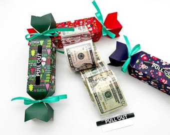 May include: Christmas-themed paper crackers in red, green, and blue, tied with green ribbons. The crackers have festive patterns and the text "PULL OUT". Several crackers are open, revealing US dollar bills.