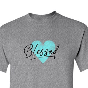 May include: A heather grey t-shirt with a blue heart and the word "Blessed" written in black script.