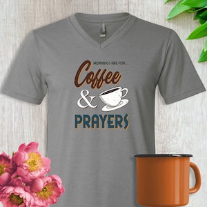 May include: Gray V-neck t-shirt with the text "Mornings are for... Coffee & Prayers" in a vintage style font. A stylized coffee cup with brown coffee is pictured next to the text.
