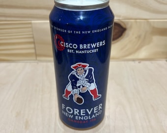 Op de afbeelding: Een blauwe en witte blikkerzen met een witte kaars erop. De blik heeft een afbeelding van een voetballer en de tekst "CISCO BREWERS EST. NANTUCKET FOREVER NEW ENGLAND GAMEDAY IPA".