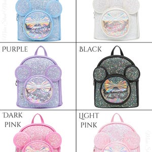 May include: Six glitter backpacks with clear plastic windows and a bow. The backpacks are in the colours blue, white, purple, black, dark pink, and light pink.