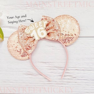 May include: Rose gold sequined Minnie Mouse ears headband with a white "Sweet 16" sign attached to the bow.