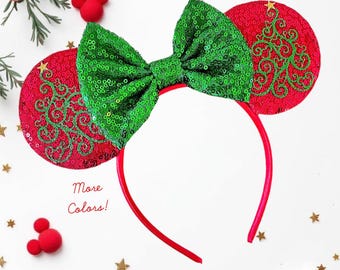 May include: A festive headband with red sequined ears featuring a green Christmas tree design. The headband has a bright green sequined bow and a red band. The text "More Colors!" is visible.
