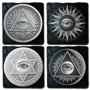 May include: Set of four black slate coasters with silver-colored, detailed designs. Each coaster features an eye symbol within geometric shapes, including a triangle, sun, and star. The designs are intricate and symmetrical.