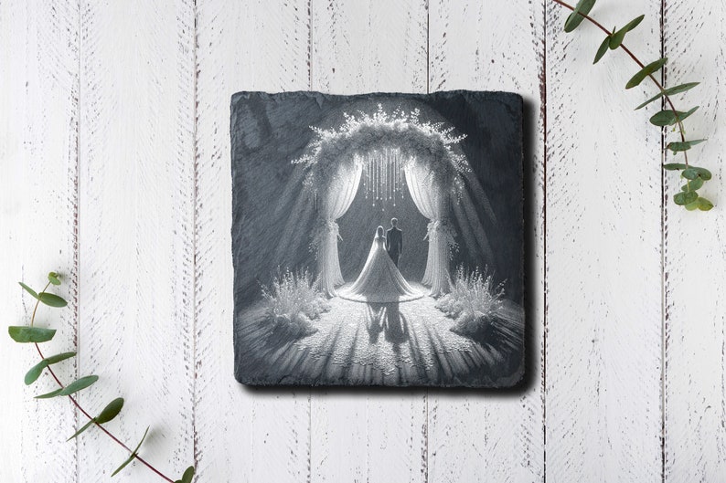 May include: A black and white photo of a wedding couple standing under an archway decorated with flowers and lights. The photo is engraved on a black slate coaster.