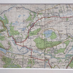 Könnte beinhalten: Eine Vintage-Karte der Gegend von Strathpeffer und Dingwall in Schottland. Die Karte zeigt Flüsse, Seen, Wälder, Straßen und Städte. Die Karte ist in Schwarz, Braun, Grün und Blau auf weißem Hintergrund gedruckt.