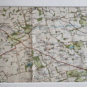 Może przedstawiać: Antyczna mapa angielskiej wsi, przedstawiająca szczegółową sieć dróg, rzek i miast. Mapa jest wydrukowana w czerni i bieli z zielonymi i brązowymi akcentami, podkreślającymi naturalne cechy regionu. Mapa zawiera nazwy miejscowości, takie jak Kirkhapton, Kirkharl i Bolam.