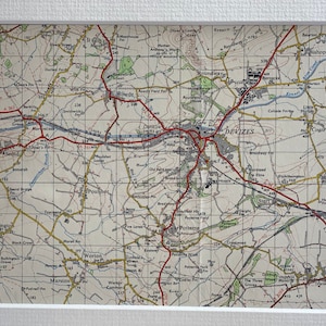 Puede incluir: Un mapa vintage de la zona alrededor de Devizes, Inglaterra, con líneas rojas que indican carreteras y líneas azules que indican ríos. El mapa muestra las ciudades de Devizes, Poulshot, Worton, Marston, Bulkington, Bishops Cannings y Urchfont.