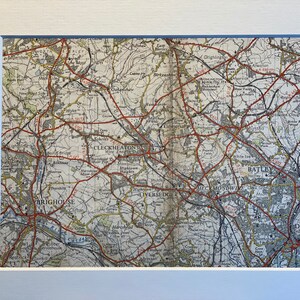 Könnte beinhalten: Eine Vintage-Karte der Gegend um die Städte Brighouse, Cleckheaton, Liversedge, Heckmondwike, Batley und Dewsbury in West Yorkshire, England. Die Karte ist in Schwarz, Rot und Braun auf cremefarbenem Hintergrund gedruckt. Die Karte zeigt Straßen, Eisenbahnen, Flüsse und andere geografische Merkmale.