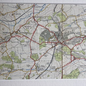May include: A vintage map of the Corby area in England, showing roads, towns, and landmarks. The map is printed on paper and has a white border.