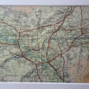 Könnte beinhalten: Eine Vintage-Karte der Gegend von Killarney in Irland, die Straßen, Flüsse und Städte zeigt. Die Karte ist auf Papier gedruckt und hat einen verblassten, antiken Look.