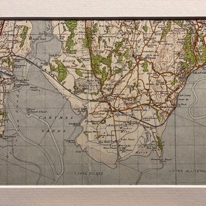 May include: An antique map of the Cartmel Sands area in England. The map shows the coastline, rivers, and roads. The map is printed in black and white with some areas highlighted in green and brown.