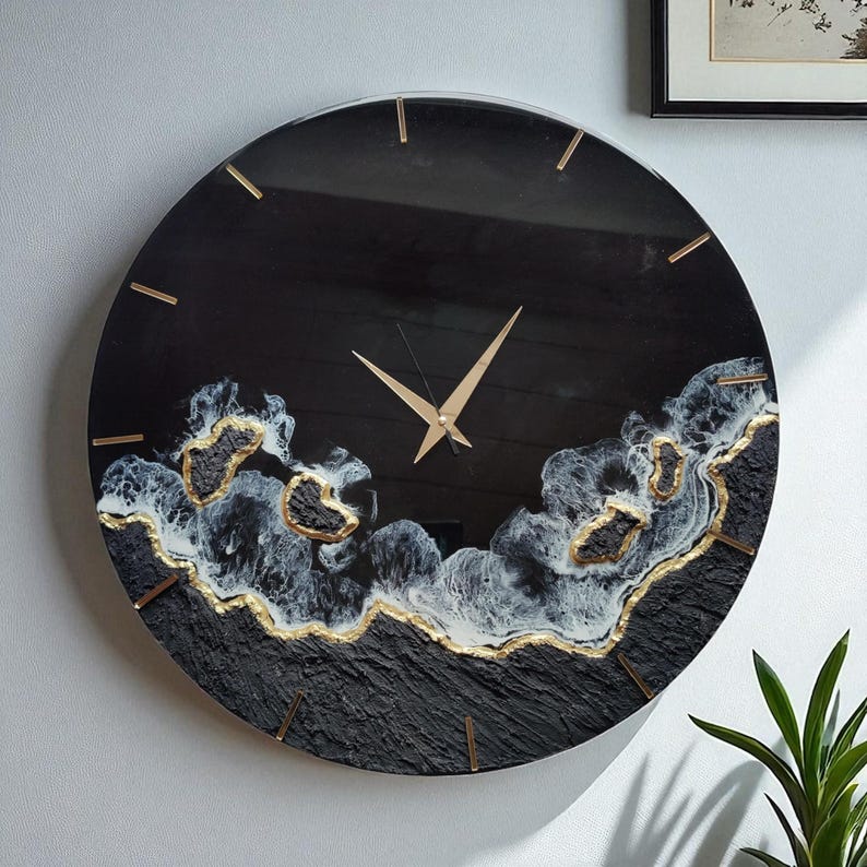 Handgefertigte schwarze Wanduhr aus Epoxidharz mit goldenen Details – modernes Design für stilvolle Wohnräume.
