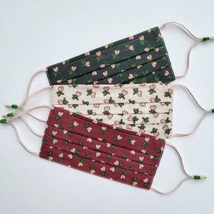 Masque de Noël doublé de soie. Impression de petites boules de houx. Trois couches, fil nasal, lavable.