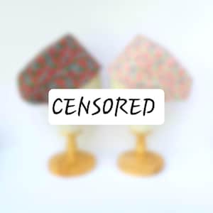 May include: Two fabric covered cake stands with a white label that says "CENSORED" in black text.