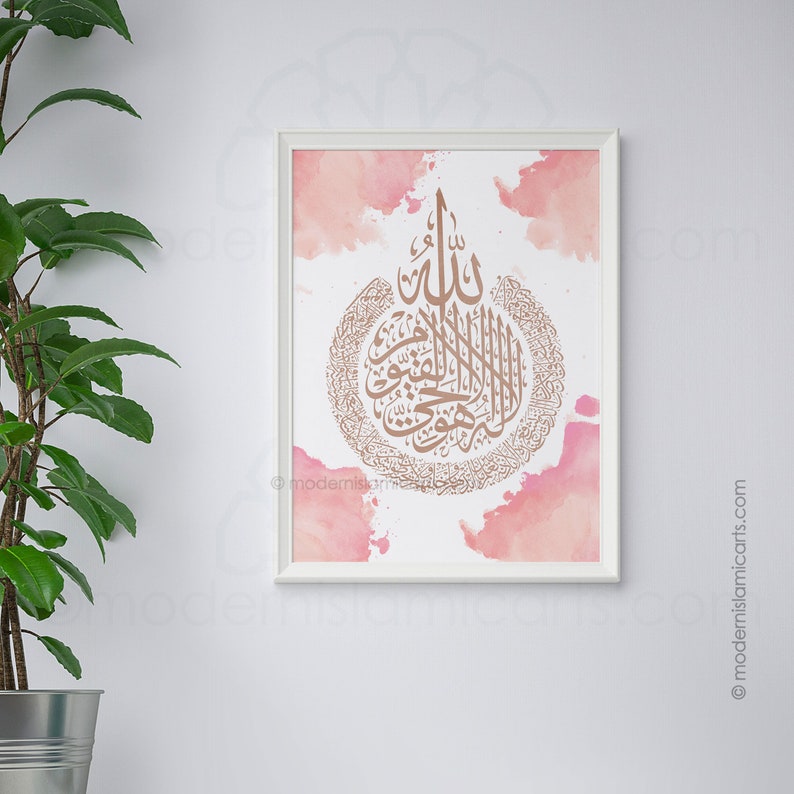 May include: A framed print with a pink watercolor background and a gold calligraphy design of an Islamic prayer. The prayer is in Arabic script and is surrounded by a circle of smaller Arabic script.