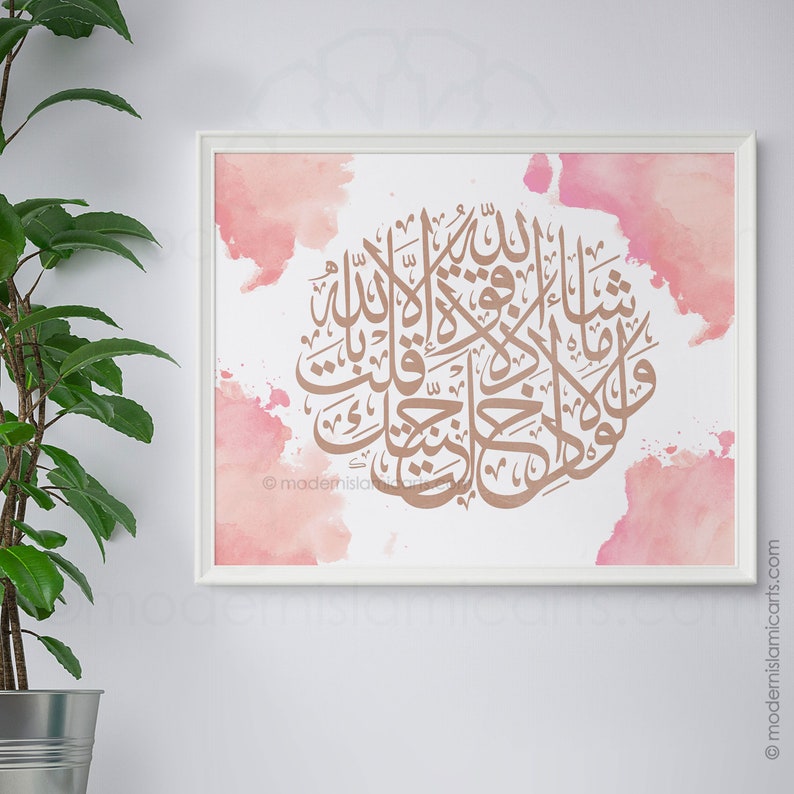 May include: A framed print with a pink watercolor background and gold calligraphy in Arabic script. The text reads "Subhana-alladhi sakh-khara-lana hadha wa ma kunna lahu muqrinin wa inna ila Rabbi-na la munqalibun".