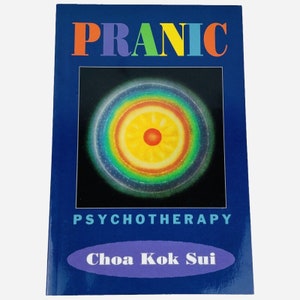 Puede incluir: Portada de libro con el título "Pranic Psychotherapy" en letras arcoíris y el autor "Choa Kok Sui" en un óvalo morado. La portada presenta una imagen colorida de un círculo con un centro rojo y un anillo exterior amarillo.