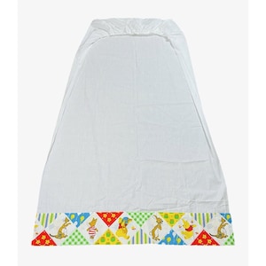 May include: White fitted sheet with a colorful border featuring Winnie the Pooh and friends. The border has a patchwork design with yellow, green, red, and blue squares. The characters include Winnie the Pooh, Piglet, Tigger, Eeyore, Rabbit, and Kanga.