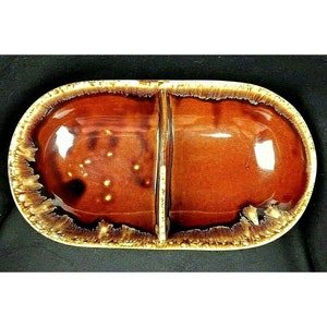 May include: A divided serving dish with a brown and gold glaze. The dish has two sections and a raised divider in the center.