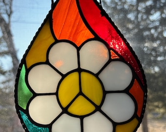 Símbolo de la paz con forma de lágrima de arcoíris en vitral