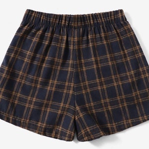 K&ouml;nnte beinhalten: Marineblaue und braune Shorts mit Karomuster und elastischem Bund. Die Shorts haben ein klassisches Karomuster in einem dunkelblauen und braunen Farbschema. Die Shorts sind aus einem weichen, bequemen Material gefertigt.