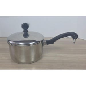 May include: A stainless steel saucepan with a lid and a black handle. The lid has a black knob. The handle has a loop at the end. The saucepan is sitting on a light brown wooden surface.